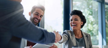 Meeting, partnership and business people shaking hands in the office for a deal, collaboration or onboarding. Diversity, professional and employees with handshake for agreement, welcome or greeting