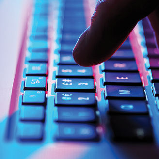 fotografía de una mano escribiendo en un teclado de computadora