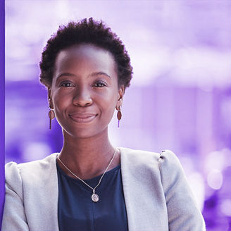 A black woman wearing a suit smiles