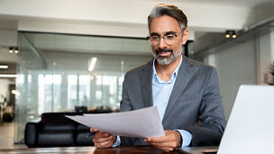 A man is holding a document at the office
