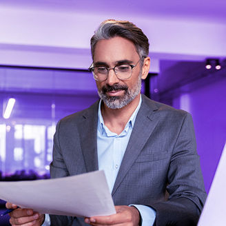 A man is holding a document at the office