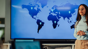 A woman stands next to world map
