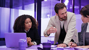 Three colleague are discussing in a meeting room