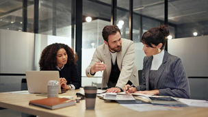 Three colleague are discussing in a meeting room