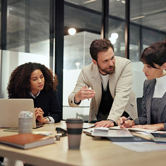 Three colleague are discussing in a meeting room