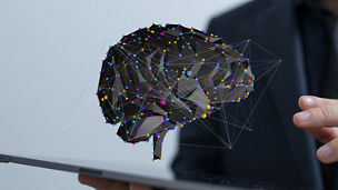 A 3D rendering of digital brain in front of a male holding tablet