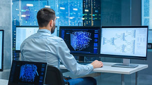 A man is working by using a multiple computer