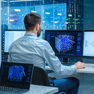A man is working by using a multiple computer