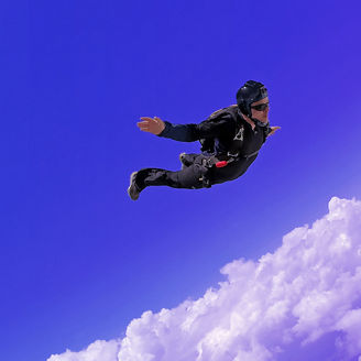Man jumping in the sky with a parachute
