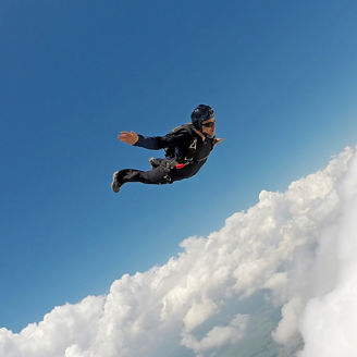 Man jumping in the sky with a parachute