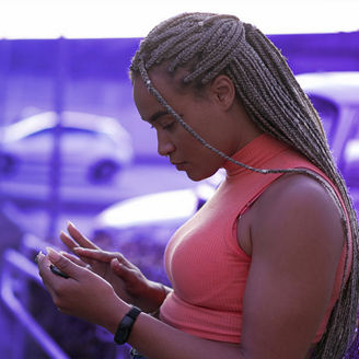 A black woman looks at her phone