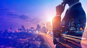Side profile of a man in a suit with a hand resting on the chin, overlaid with digital interface graphics against a blurred city skyline and illuminated roadway at dusk