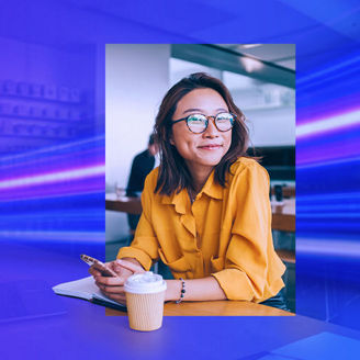 Woman smiling and holding her phone next to her takeout coffee cup