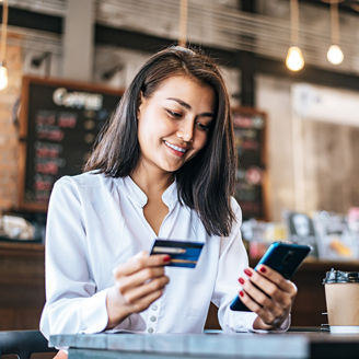 Pay for goods by credit card through a smartphone in a coffee shop.