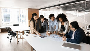 people standing around a desk and working