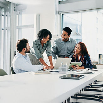 A group of people are working together around a desk