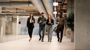 A group of people walking with a coffee cup in their hand