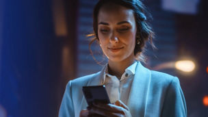 A person in a shirt and jacket looking at their phone