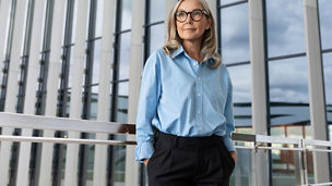 Fotografía de una mujer ejecutiva caminando en la calle frente a un edificio