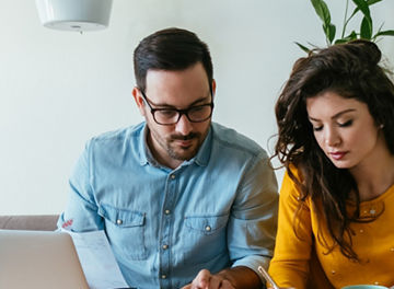 Two people working together on a laptop