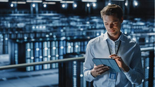Man in server room on tablet