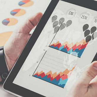 Man looking at graphs on a tablet 