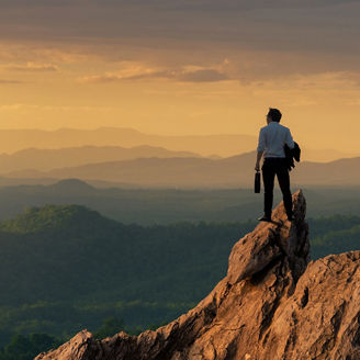 Man on mountain looking at sunset