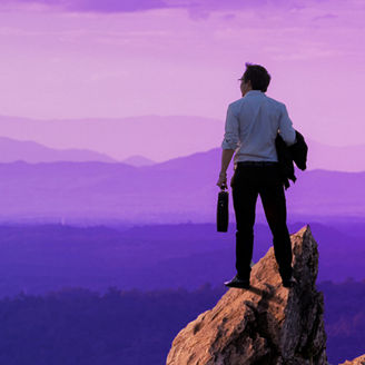 Man on mountain looking at sunset