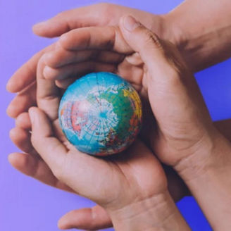 Two hands holding a globe.