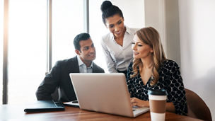 Three people sitting at a table in a meeting