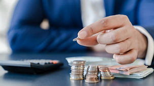 Gros plan d'un homme comptant de l'argent à un bureau.