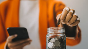 Someone puts coins in a jar