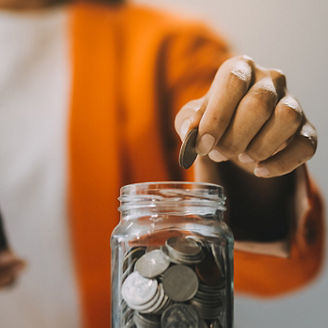 Someone puts coins in a jar