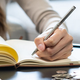 Someone is writing something down in a notebook