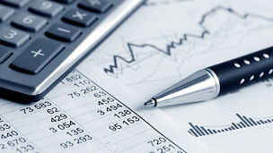 Tables with numbers on paper with a calculator and a pen