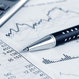 Tables with numbers on paper with a calculator and a pen