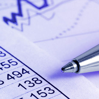 Tables with numbers on paper with a calculator and a pen