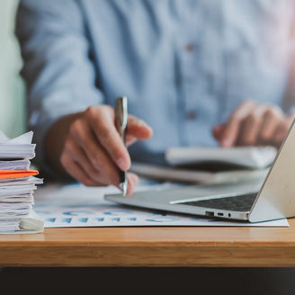 A man is sitting at a desk and writing something down