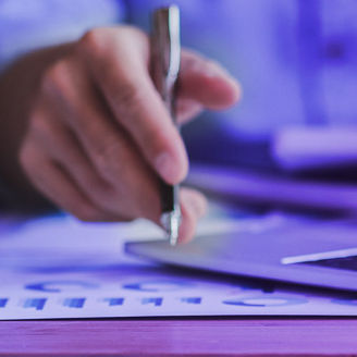 A man is sitting at a desk and writing something down