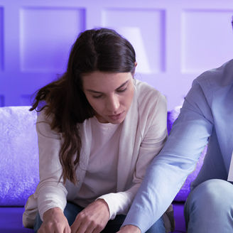 Man showing a woman some documents while sitting on a sofa