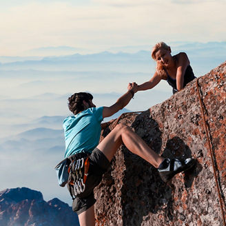 Teamwork couple helping hand trust in inspiring mountains