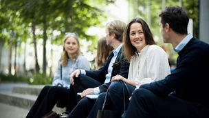 Ung person snakker med en kollega utendørs