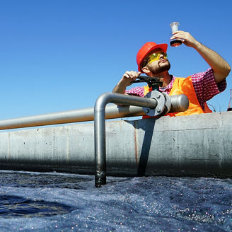 Man testing quality of water at waste water treatment plant