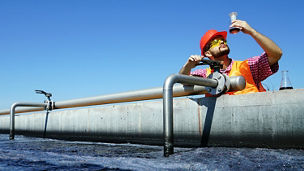 Man testing quality of water at waste water treatment plant