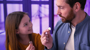 Vader en dochter die een muntstuk vasthouden