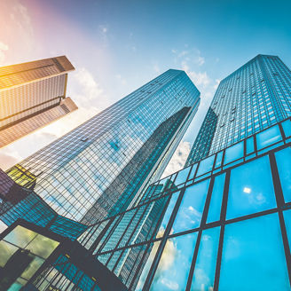 Bottom view of modern skyscrapers in business district in beautiful evening light at sunset with monochrome retro vintage Instagram style filter and lens flare effect