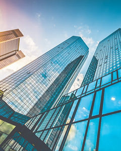 Bottom view of modern skyscrapers in business district in beautiful evening light at sunset with monochrome retro vintage Instagram style filter and lens flare effect