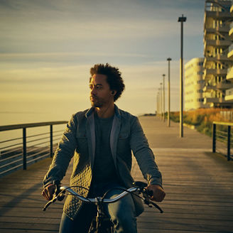 Shot of a young man going for a bicycle ride along the promenade