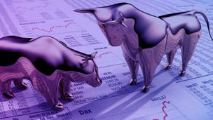 Eine Bärenstatur und eine Bullenstatur auf einen Aktienpapier stehen sich gegenüber