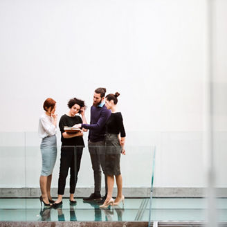 A group of young businesspeople standing near staircase, talking. Copy space.